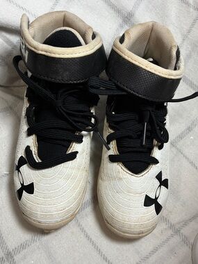 Under Armour Kids White and Black Mid-Top sports cleats and